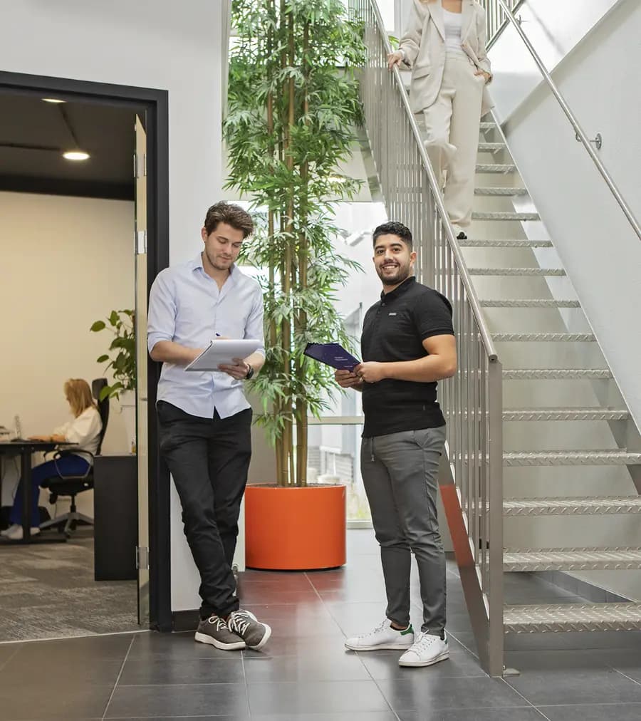 Colleagues by the stairs in the office hallway